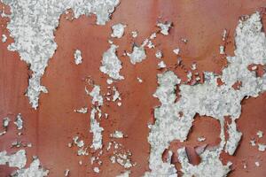 Cracked and peeling paint on a concrete wall as texture, background photo