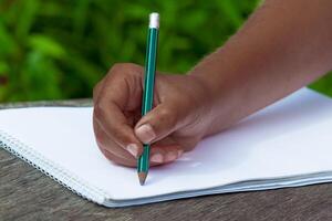 black kid's hand draws in pencil photo