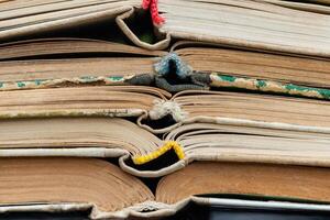 Closeup view of pile a opened books as background, texture photo