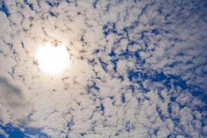 the sun shines through cirrus clouds photo