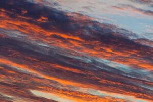 Clouds illuminated by sunlight on a evening sky photo