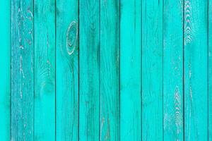 Grungy painted in turquoise wooden wall panels as texture, background photo