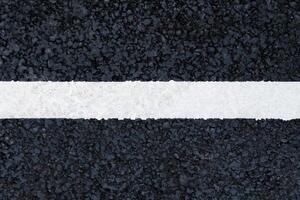 Horizontal white marking line on the asphalt road background, texture, abstract photo