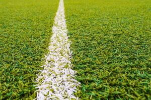 Sports field with artificial grass and white markings photo