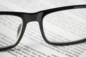 Close up view of a glasses on the open book photo