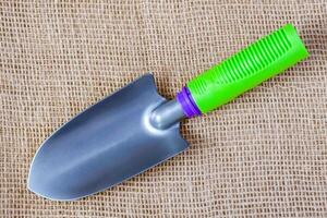 Small garden tool - trowel on the sackcloth surface photo