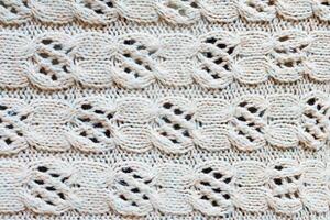 Knitted from the wool with an openwork pattern background photo