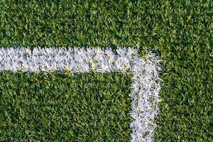 Sports field with artificial grass and white markings photo