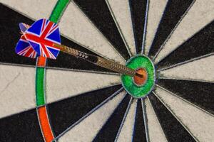 Fragment of dartboard with dart in bullseye photo