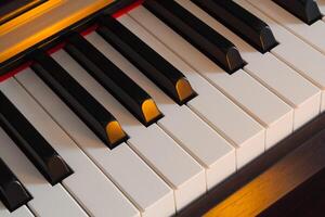 Piano keys illuminated by with warm light photo