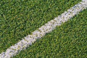 Sports field with artificial grass and white markings photo