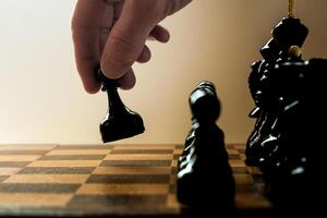 Chess player makes a move the black pawn forward photo