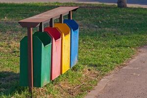 Four colors dirty recycle bins or trash can in the park photo