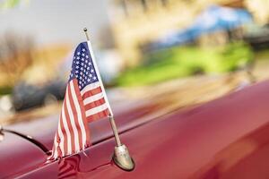 American Flag on the Hood of a Red Car photo