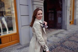 Smiling fashionable woman with sunglasses crossing the city street and looking at camera photo