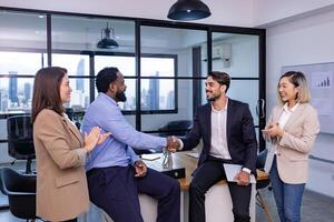 Caucasian business team leader congratulate his teammate employee for outstanding achievement team performance by shaking hand in modern office workplace with skyscraper view photo