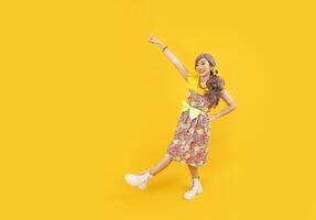 asiático hippie mujer vestir en Años 80 Clásico Moda con vistoso retro ropa mientras bailando aislado en amarillo antecedentes para lujoso atuendo fiesta y popular cultura concepto foto