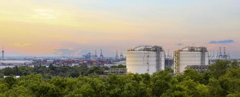 Panorama view of heavy industrial estate including crude oil industry and logistics port that located next to high density forest which create pollution and contamination to the wildlife photo