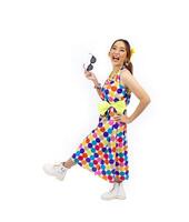Asian hippie woman dress in 80s vintage dress fashion with colorful retro funk disco clothing while dancing isolated on white background for fancy outfit party and pop culture photo
