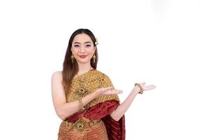 Thai woman in elegant wealthy traditional dress doing hand presenting gesture for promoting culture in Thailand isolated on the white background photo