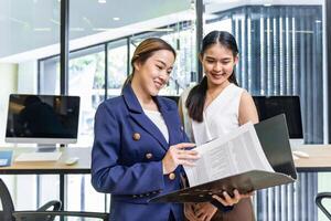 Businesswoman team leader is guiding young member to business success by showing information for goal achievement for startup and creativity project concept photo