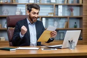 Happy successful boss received mail notification envelope with good news message, financier at workplace inside office, businessman happy with successful delivery results. photo