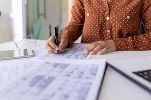 Close-up of hands of a woman working in the office at the table, signing business papers, working with documents, paperwork. photo