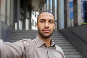 Professional young African American businessman captures a selfie, epitomizing ambition and modern career lifestyle. photo