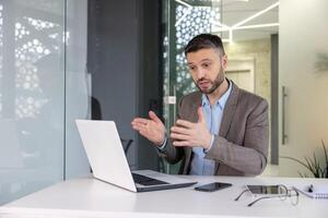 confidente masculino profesional utilizando ordenador portátil a explique conceptos en un contemporáneo oficina ambiente, ilustrando eficaz comunicación. foto