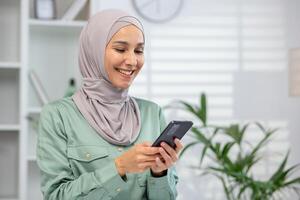 alegre musulmán mujer vistiendo un hijab se involucra con su teléfono inteligente, retratar conectividad y moderno estilo de vida. foto