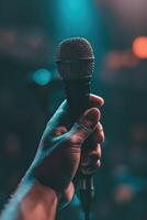 The energy and excitement of a live performance, with a hand holding up a microphone poised to capture the artist's voice photo