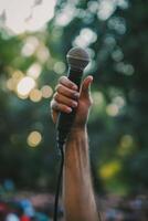 A hand holding up a microphone in a professional setting, symbolizing the power of speech and communication. photo