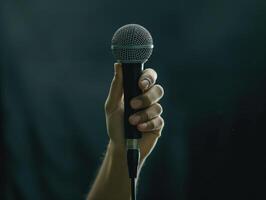 A hand holding up a microphone at a special event or celebration photo