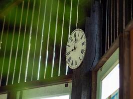 redondo de madera reloj colgando en un de madera pared. foto