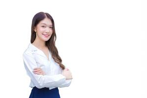 joven asiático mujer de negocios vistiendo blanco camisa y en pie con confianza con su brazos cruzado sonrisa ella trabajando el oficina mientras aislado blanco antecedentes. foto
