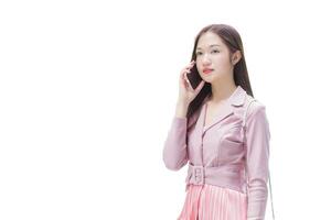 Young asian business professional woman in pink dress is calling phone seriously confident with someone at building while isolated white background. photo