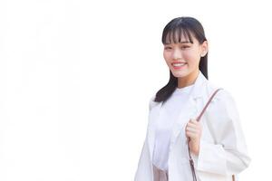 Confident young business Asian working woman who wears a white shirt and shoulder bag smiles happily while she is walking to work at office while isolated white background. photo