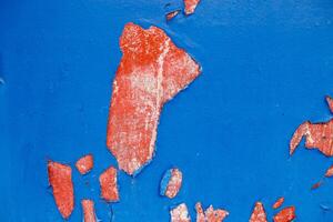 Old blue paint peeling from red concrete wall texture background. photo