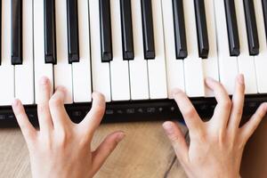 Child hands is playing, learning and practicing the piano. Piano chords In the key. photo