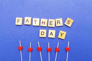 Father's day word made by wooden cubes. Red hearts on a blue background. photo