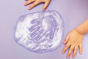 child playing with a slime at home. kid stretching colorful slime. DIY concept. photo