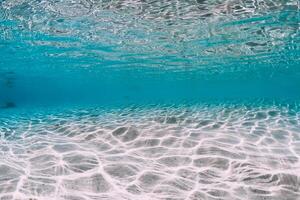 Turquoise ocean water with sandy bottom underwater. photo