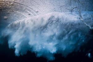 Barrel wave break in ocean with sunset or sunrise light. Underwater view of surfing wave photo