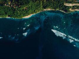 Aerial view of coastline with ocean waves and powerful current canal in Bali. Green bowl beach photo