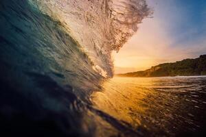 Surfing wave breaking in ocean with warm sunset light. photo