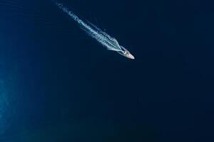 Speedy motor boat is sailing in blue ocean. Aerial view photo