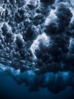 Ocean wave and foam underwater with clear water. Underwater clouds made by powerful wave photo