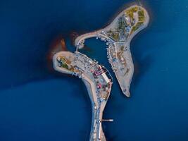 Aerial view of coastline with blue sea, island and lighthouse in Utrish photo