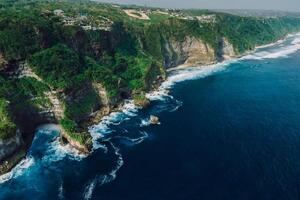 Coastline with rocks and ocean with waves in Bali. Aerial view. photo