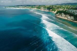 Aerial view of ocean with long waves and coastline on Impossibles beach in Bali photo